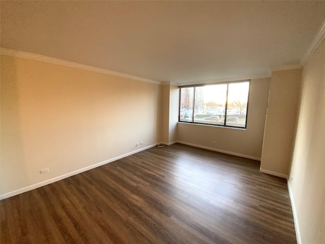 empty room featuring ornamental molding and dark wood-type flooring