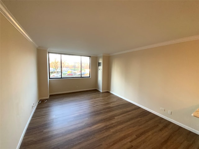 spare room with crown molding and dark wood-type flooring