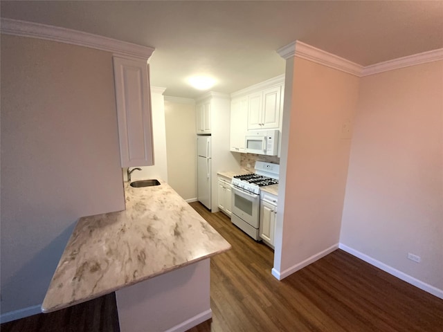 kitchen with white appliances, dark wood-type flooring, white cabinets, crown molding, and sink