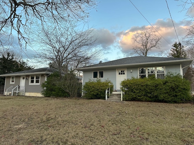 back house at dusk featuring a yard