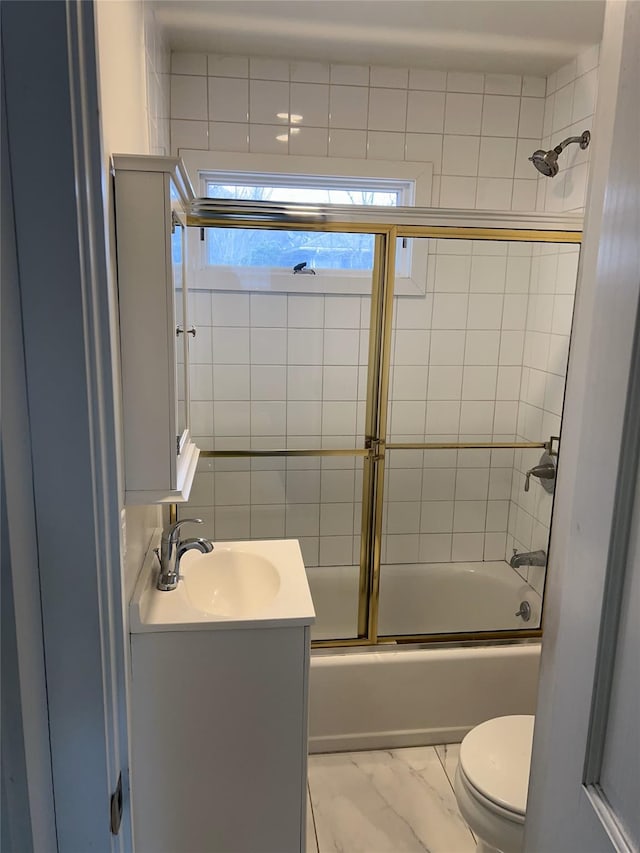 full bathroom featuring vanity, bath / shower combo with glass door, and toilet