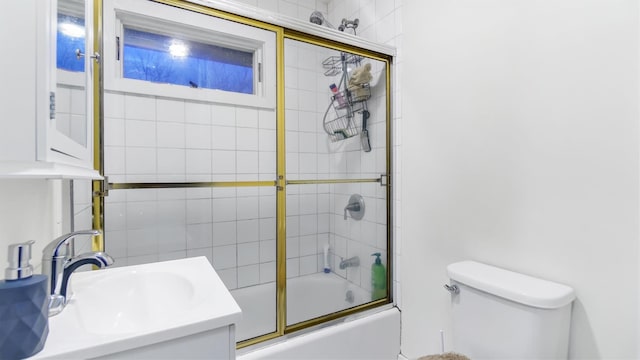 full bathroom featuring toilet, shower / bath combination with glass door, and sink