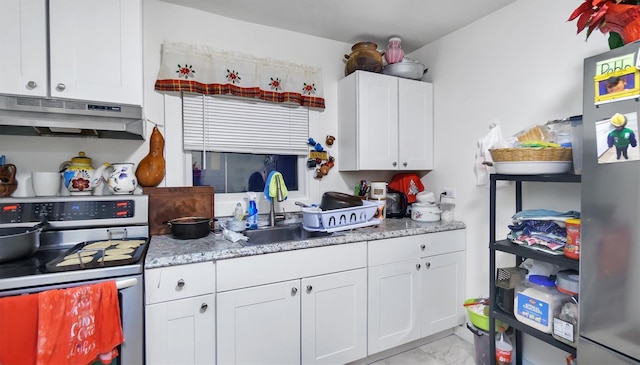 kitchen featuring stainless steel range, white cabinets, and sink