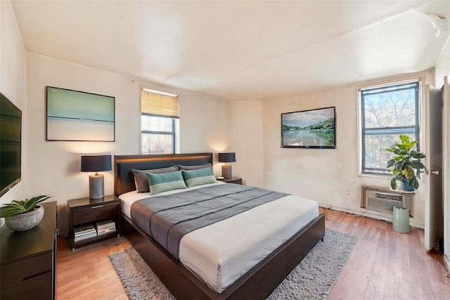 bedroom featuring light wood-type flooring and a wall unit AC