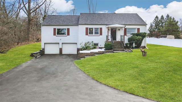 ranch-style house featuring a shingled roof, fence, a garage, driveway, and a front lawn