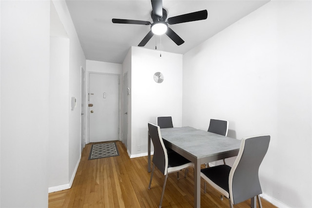 dining space with light wood-type flooring and baseboards