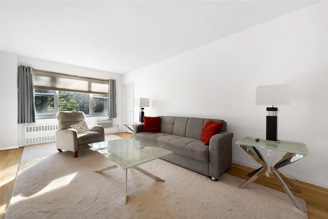 living area with radiator, baseboards, and light wood finished floors