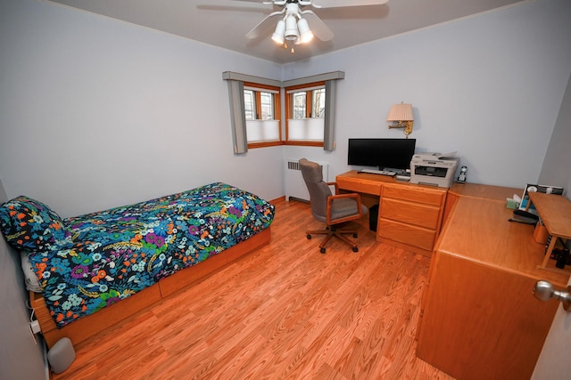 bedroom featuring hardwood / wood-style floors, ceiling fan, and radiator heating unit