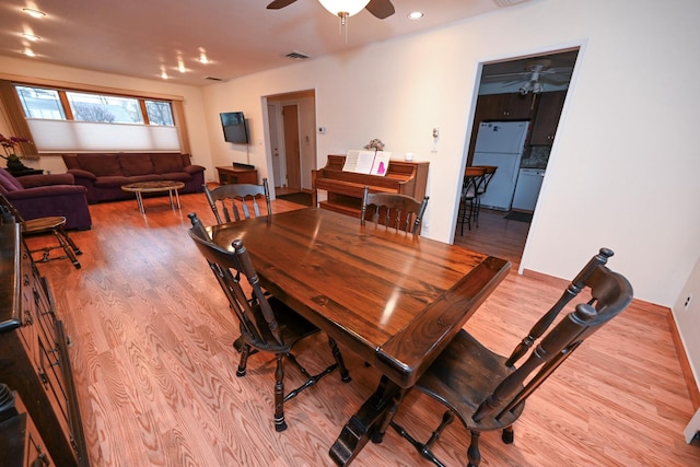 dining area with light hardwood / wood-style floors and ceiling fan