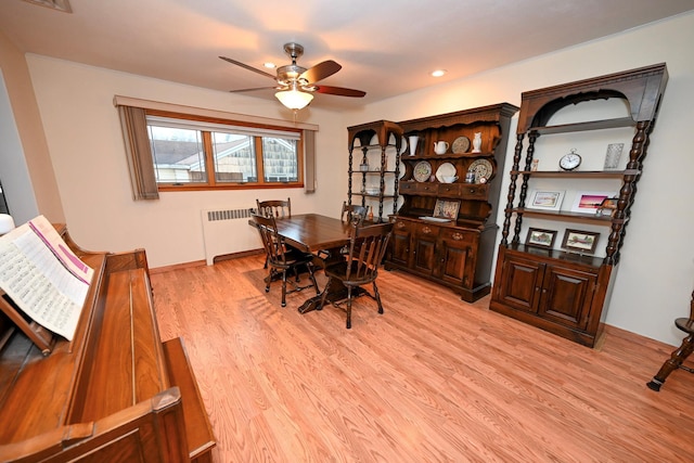 dining room with ceiling fan, light wood-type flooring, and radiator heating unit