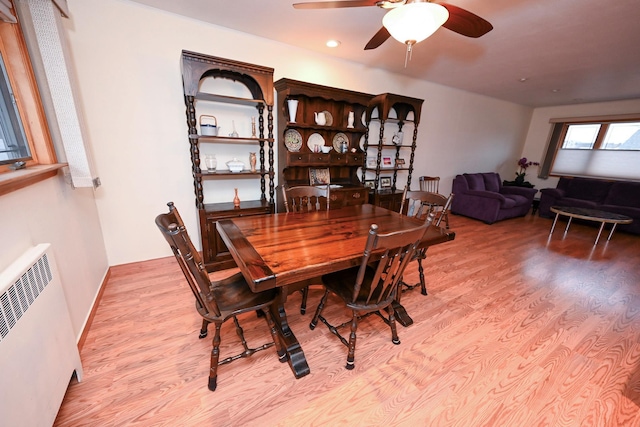 dining space with ceiling fan, radiator, and light hardwood / wood-style flooring