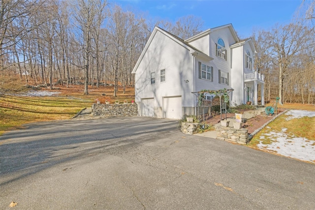 view of side of home with a balcony and a garage