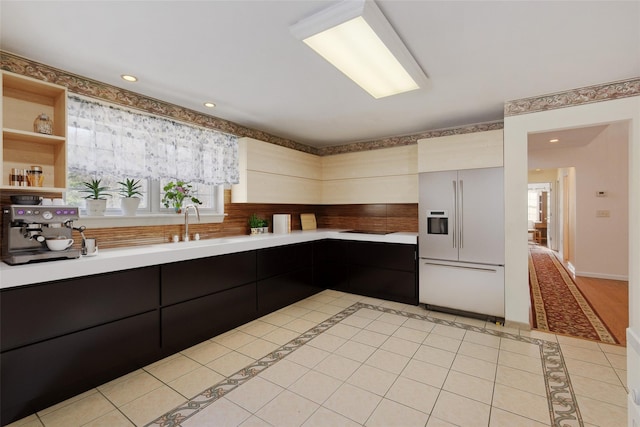 kitchen featuring light tile patterned flooring, sink, white built in refrigerator, and a wealth of natural light