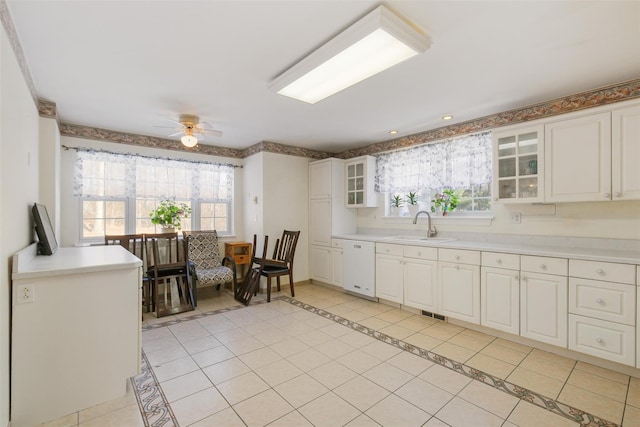 kitchen with dishwasher, white cabinets, sink, ceiling fan, and light tile patterned flooring