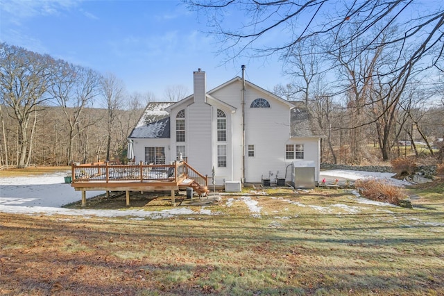 back of property with a lawn, central AC unit, and a deck