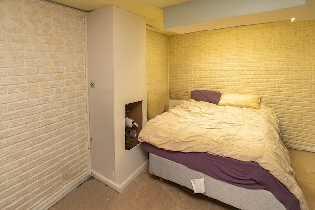 bedroom with carpet and brick wall