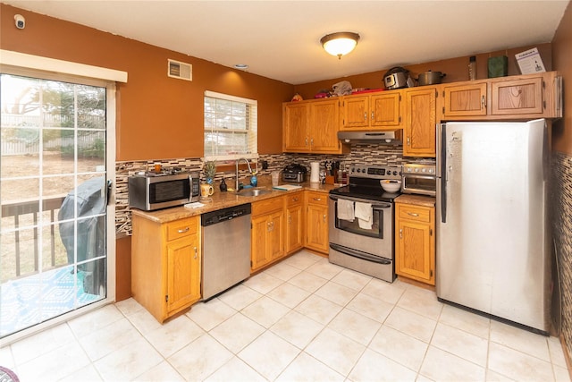 kitchen with backsplash, sink, light tile patterned flooring, and appliances with stainless steel finishes