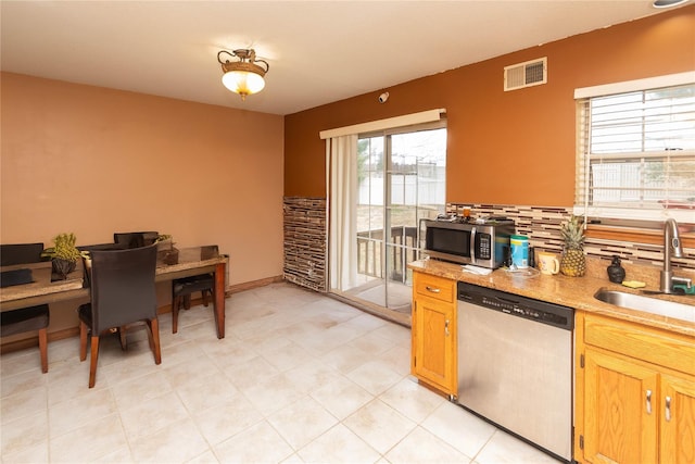 kitchen featuring appliances with stainless steel finishes, tasteful backsplash, and sink