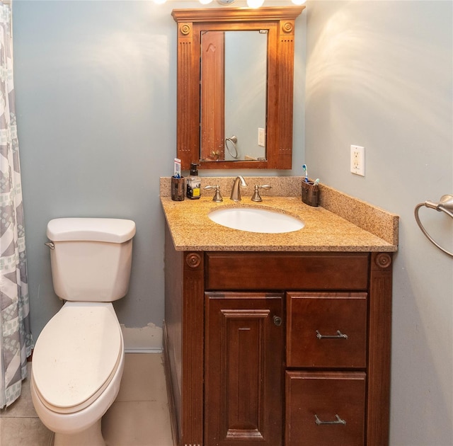 bathroom with toilet, vanity, and tile patterned floors