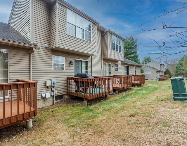 rear view of house featuring a yard and a deck