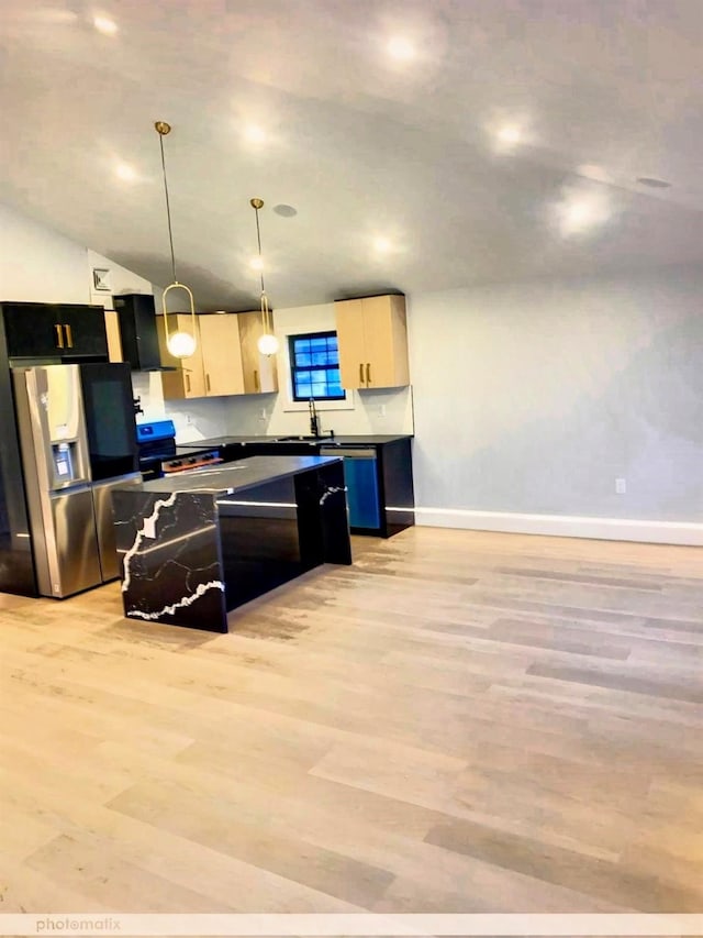 kitchen featuring stainless steel refrigerator with ice dispenser, light brown cabinetry, vaulted ceiling, light hardwood / wood-style floors, and hanging light fixtures