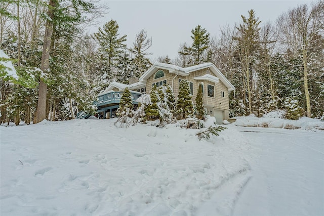 view of snow covered exterior featuring a garage and a deck