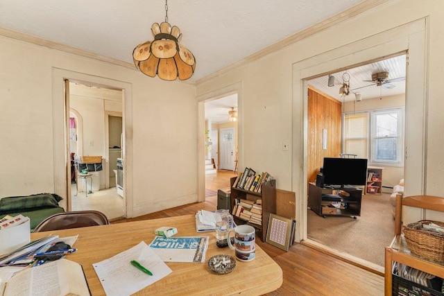 dining space featuring ceiling fan, hardwood / wood-style floors, crown molding, and a baseboard radiator