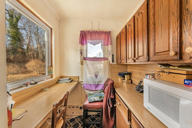 home office with plenty of natural light and ornamental molding