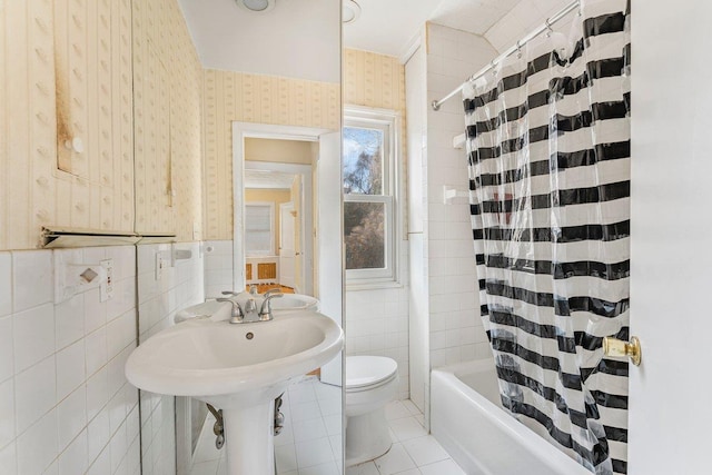 bathroom with tile walls, tile patterned flooring, shower / bath combo, and toilet