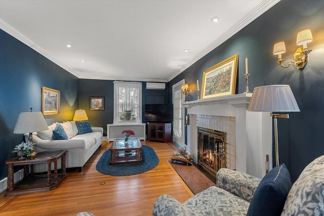 living room with hardwood / wood-style floors, ornamental molding, and a brick fireplace