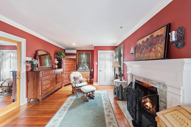 living area featuring a brick fireplace, crown molding, and light wood-type flooring