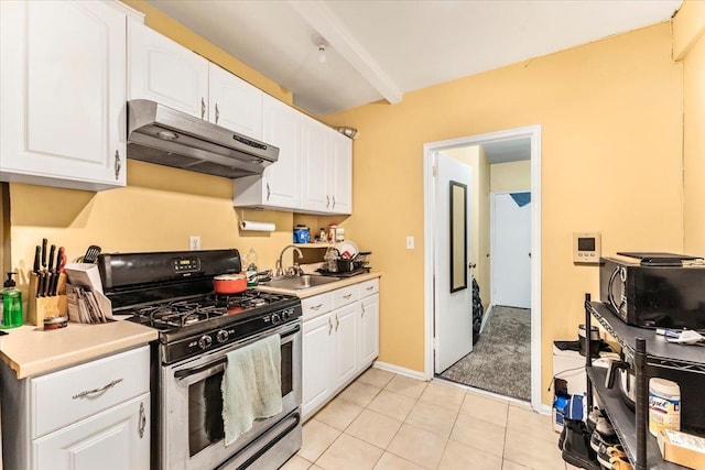 kitchen featuring white cabinets, light tile patterned floors, sink, and stainless steel gas range