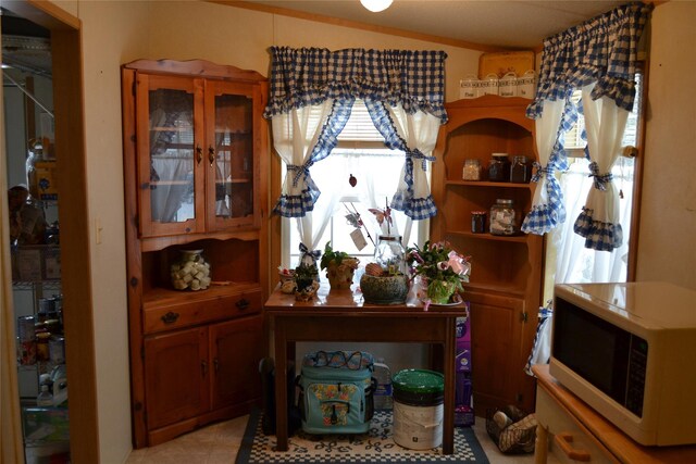 dining room with light tile patterned floors and crown molding