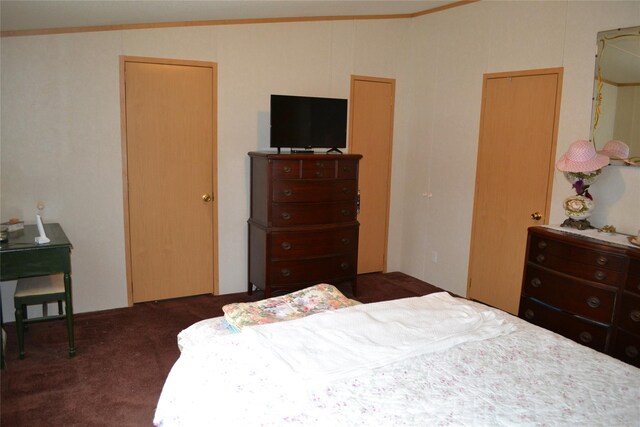 bedroom featuring crown molding, dark carpet, and lofted ceiling