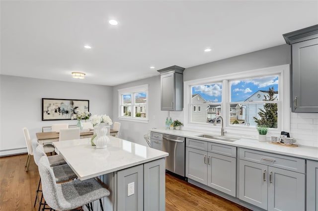 kitchen featuring stainless steel dishwasher, gray cabinets, and sink