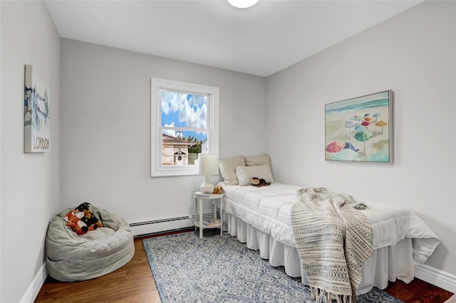 bedroom with a baseboard radiator and hardwood / wood-style flooring