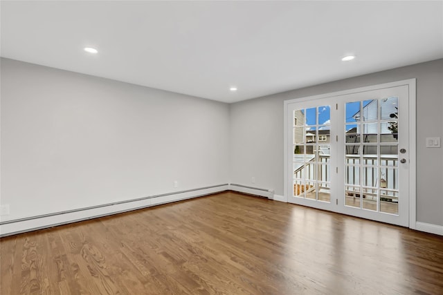 spare room with hardwood / wood-style flooring and baseboard heating