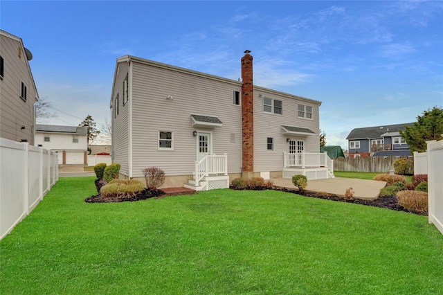 rear view of property with a patio and a lawn