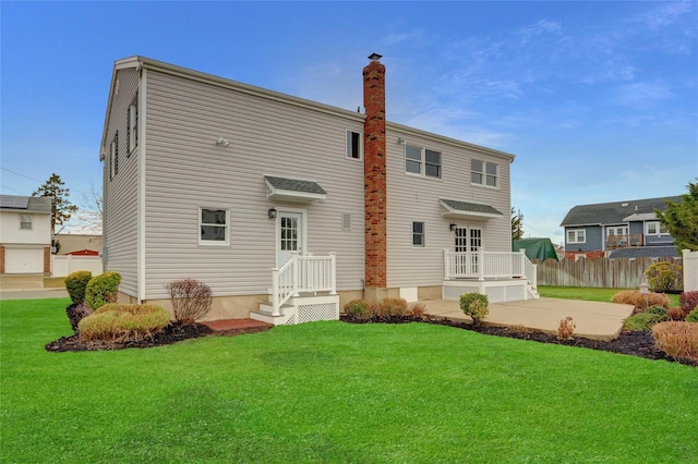 back of house featuring a lawn and a patio area