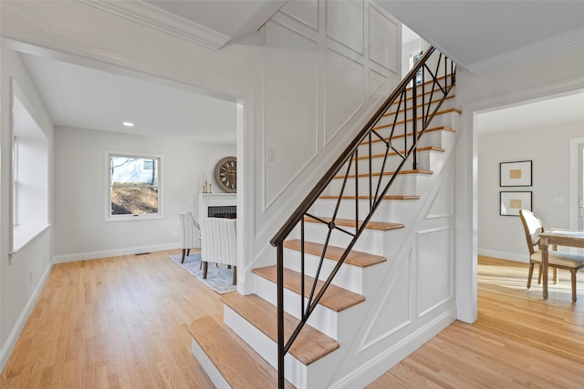 stairway with crown molding and hardwood / wood-style floors