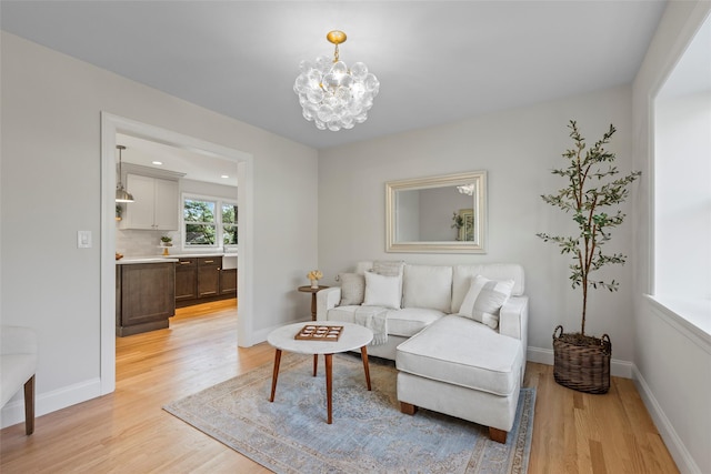 living room with a notable chandelier and light hardwood / wood-style floors