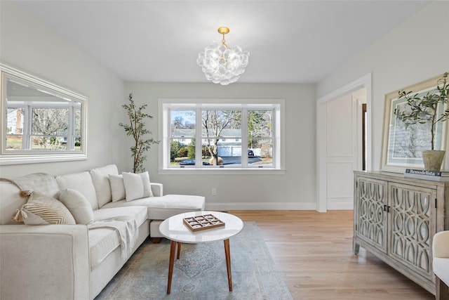 living room with light hardwood / wood-style floors and an inviting chandelier