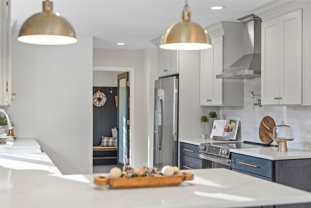 kitchen with tasteful backsplash, white cabinets, stainless steel appliances, and wall chimney range hood