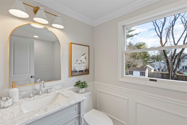 bathroom featuring vanity, toilet, a wealth of natural light, and ornamental molding