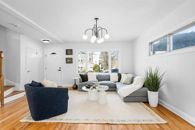 living room with a notable chandelier and light hardwood / wood-style floors