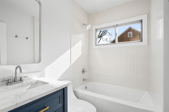 full bathroom featuring vanity, tiled shower / bath, and toilet