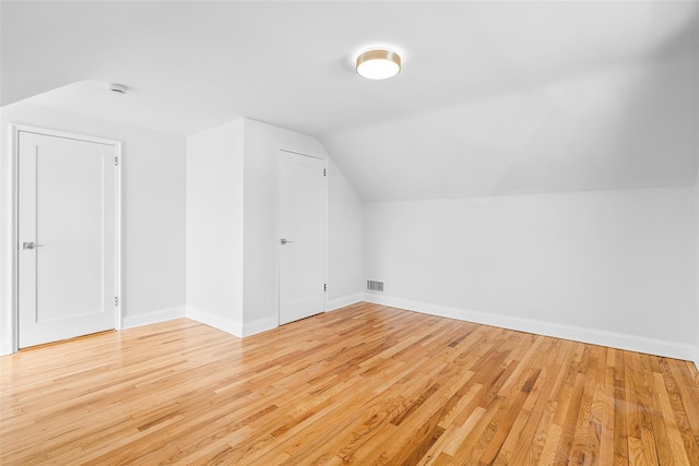 additional living space with lofted ceiling and light hardwood / wood-style floors