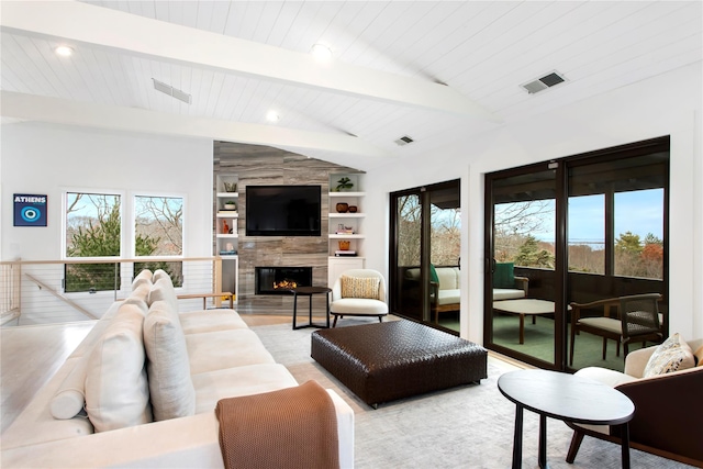 living room featuring a tiled fireplace, built in features, and vaulted ceiling with beams