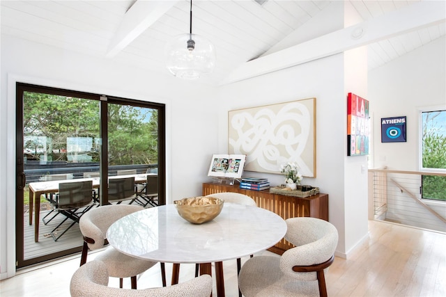 dining room with vaulted ceiling with beams, light wood-type flooring, and plenty of natural light