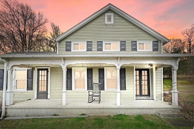 back house at dusk with covered porch